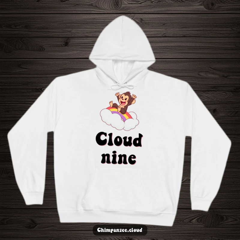 Funny and warm hoodie featuring an excited chimpanzee sliding down a rainbow onto a soft cloud, a delightful piece.