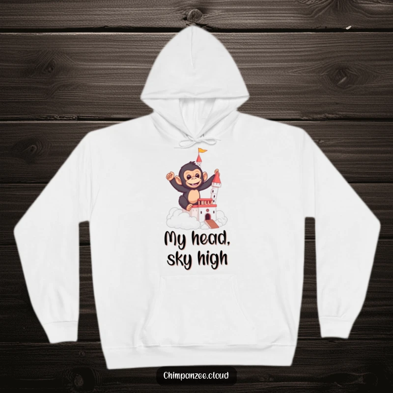 Funny hoodie depicting a mischievous chimpanzee creating a castle structure using soft, ethereal clouds.